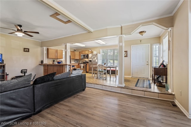 1501 S R St, Fort Smith, AR 72901 - living room featuring wood finished floors, decorative columns, a ceiling fan, crown molding, and baseboards