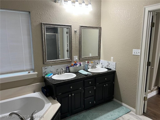 1610 Tiger Lily Ct, Greenwood, AR 72936 - bathroom featuring double vanity, a bath, wood finished floors, and a textured wall
