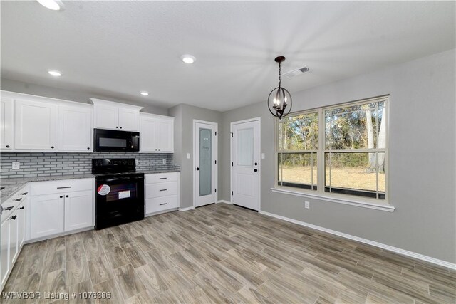 kitchen featuring black appliances, decorative backsplash, white cabinetry, and an inviting chandelier