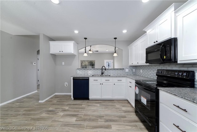 kitchen with black appliances, decorative light fixtures, white cabinets, and sink