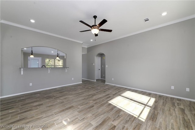 unfurnished room with ceiling fan, wood-type flooring, and ornamental molding