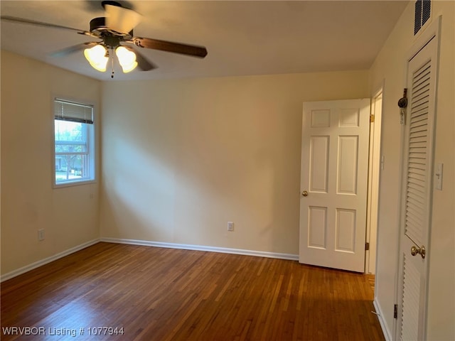 empty room featuring dark hardwood / wood-style flooring and ceiling fan