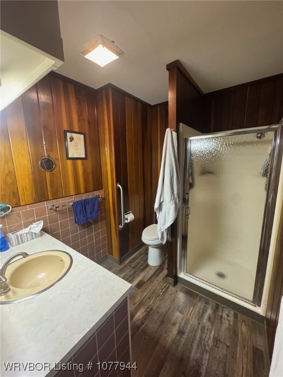 bathroom with vanity, hardwood / wood-style flooring, toilet, and a shower with door