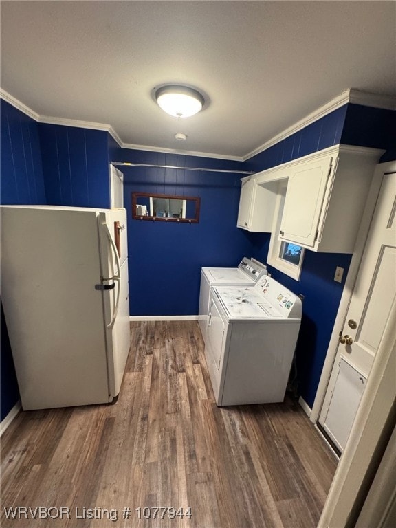 laundry room featuring washer and clothes dryer, dark hardwood / wood-style flooring, cabinets, and crown molding