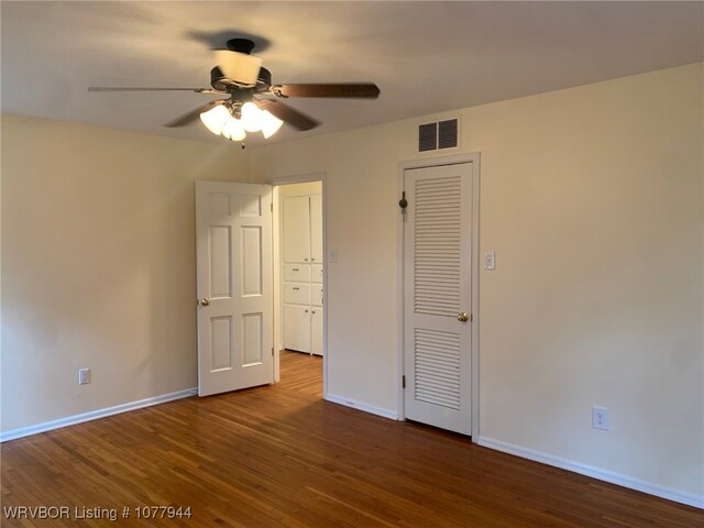 unfurnished bedroom with ceiling fan and dark hardwood / wood-style flooring