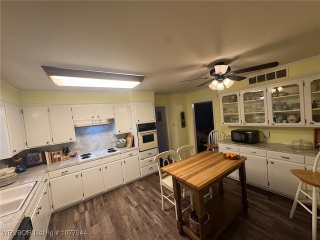 kitchen with white appliances, backsplash, sink, dark hardwood / wood-style flooring, and white cabinetry