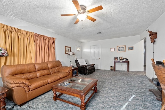 living room with ceiling fan, carpet, and a textured ceiling