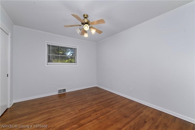 spare room featuring ceiling fan, crown molding, and dark wood-type flooring