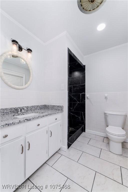 bathroom featuring vanity, toilet, crown molding, and tile walls