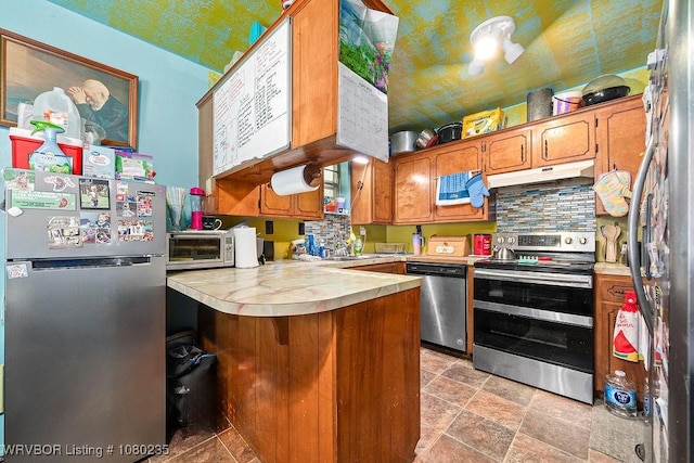5914 Asa Craig Rd, Greenwood, AR 72936 - kitchen featuring tasteful backsplash, a peninsula, appliances with stainless steel finishes, under cabinet range hood, and light countertops