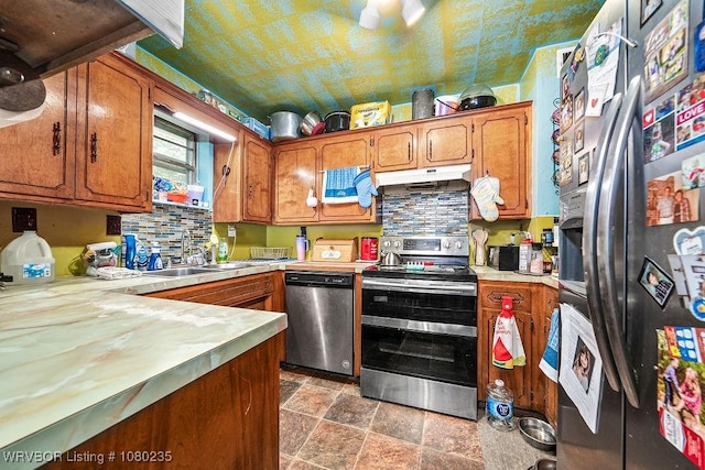 5914 Asa Craig Rd, Greenwood, AR 72936 - kitchen featuring light countertops, under cabinet range hood, appliances with stainless steel finishes, stone finish flooring, and a sink