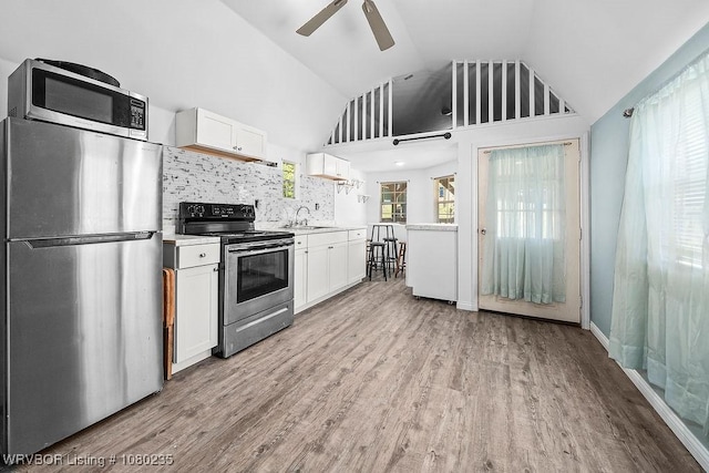 5914 Asa Craig Rd, Greenwood, AR 72936 - kitchen with a ceiling fan, white cabinets, a sink, lofted ceiling, and stainless steel appliances