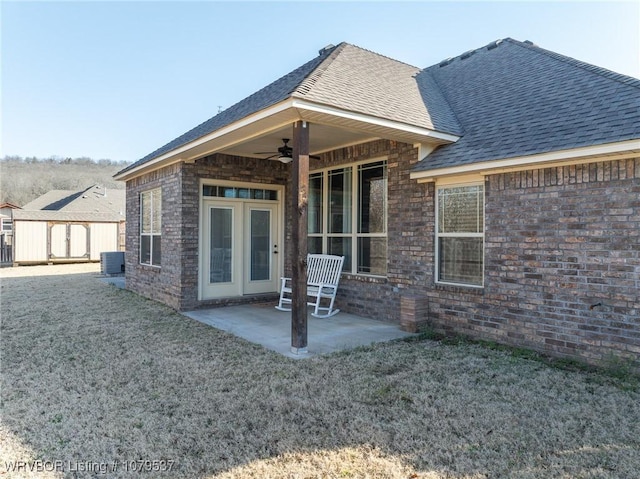 rear view of property with a patio, cooling unit, ceiling fan, a lawn, and brick siding