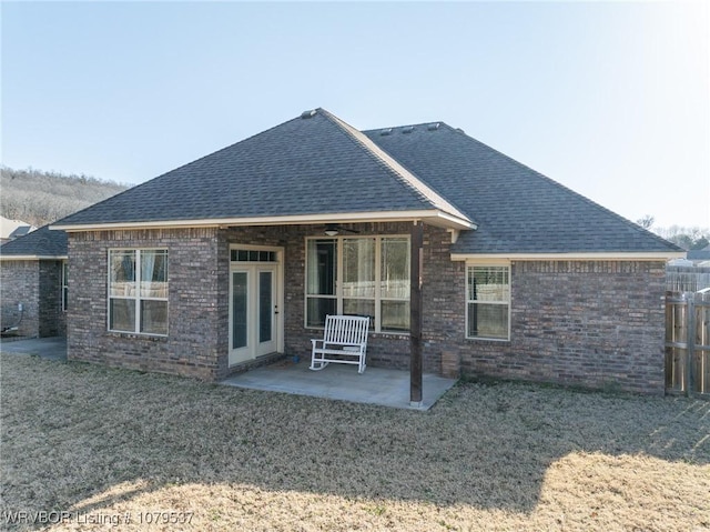 back of property with a patio, brick siding, and a shingled roof