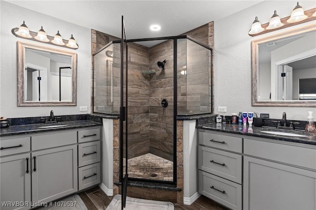 bathroom featuring a sink, two vanities, and a stall shower