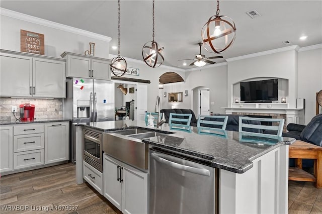 kitchen with visible vents, tasteful backsplash, open floor plan, stainless steel appliances, and arched walkways