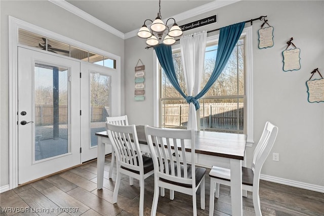 dining room featuring a notable chandelier, wood finished floors, a wealth of natural light, and ornamental molding