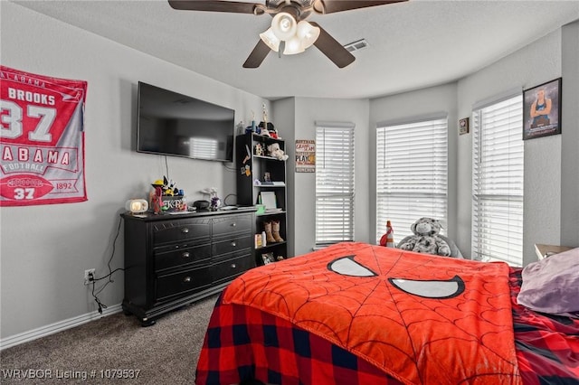 carpeted bedroom featuring multiple windows, baseboards, visible vents, and ceiling fan