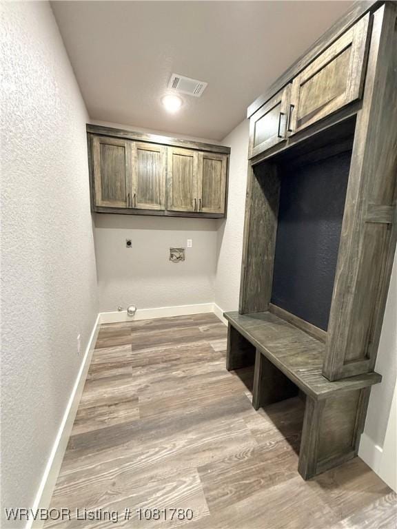 2948 N Hwy 282, Van Buren, AR 72956 - laundry area featuring a textured wall, light wood-style floors, and cabinet space