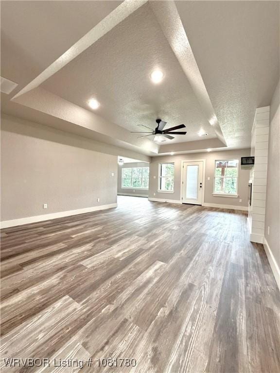 2948 N Hwy 282, Van Buren, AR 72956 - unfurnished living room with a textured ceiling, ceiling fan, wood finished floors, plenty of natural light, and a raised ceiling