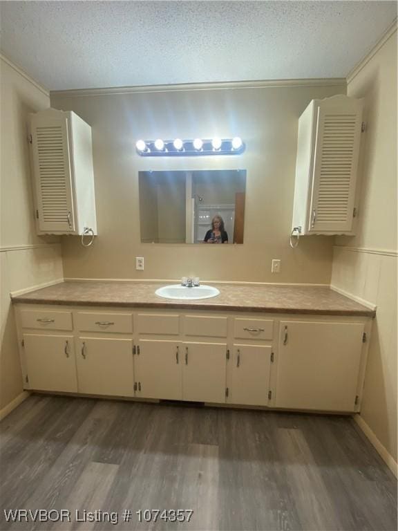 bathroom featuring crown molding, vanity, a textured ceiling, and hardwood / wood-style flooring