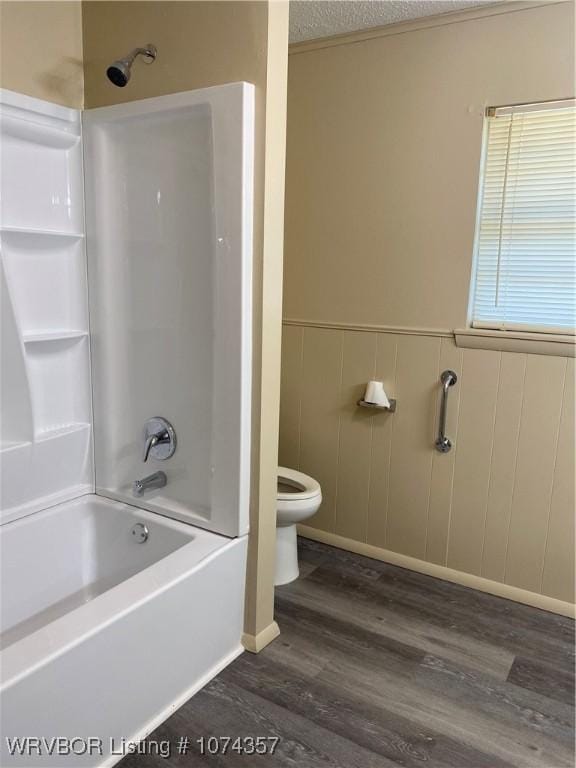 bathroom featuring shower / tub combination, a textured ceiling, hardwood / wood-style flooring, and toilet