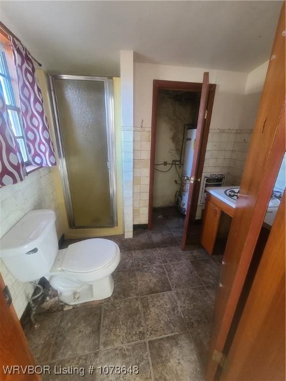 bathroom with toilet, an enclosed shower, tile walls, and gas water heater