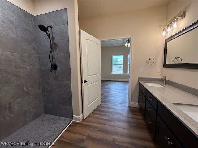 1102 Sequoyah, Spiro, OK 74959 - bathroom with wood finished floors, a tile shower, double vanity, and baseboards