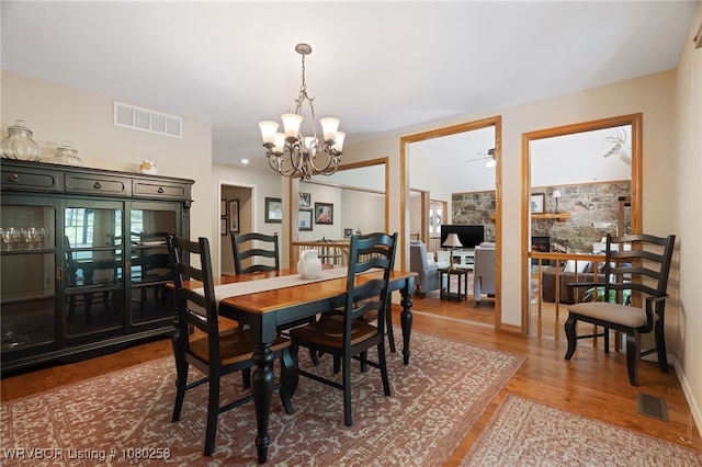 517 Ross Hampton Rd, Hackett, AR 72937 - dining space featuring wood finished floors, ceiling fan with notable chandelier, and visible vents
