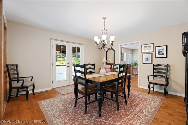 517 Ross Hampton Rd, Hackett, AR 72937 - dining room with french doors, baseboards, a chandelier, and light wood-style floors