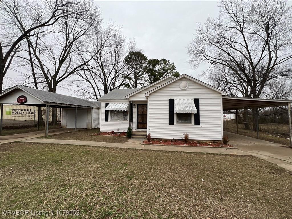 view of front of home with a front lawn and a carport