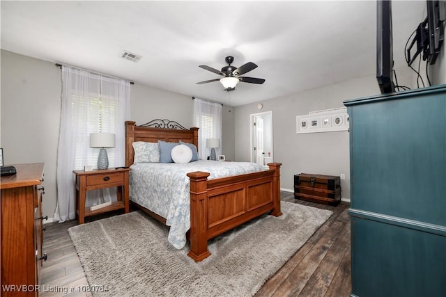 bedroom with a ceiling fan, baseboards, dark wood-type flooring, and visible vents