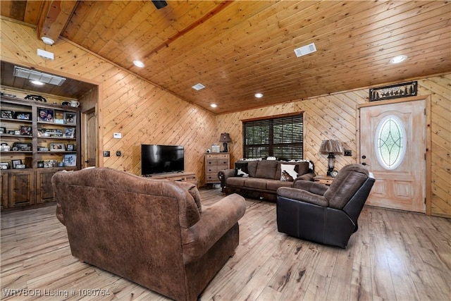 living area with wooden walls, light wood-style flooring, visible vents, and wood ceiling