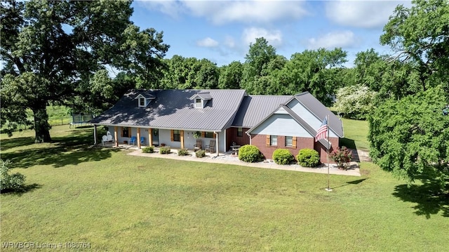 view of front of home featuring covered porch, metal roof, and a front lawn