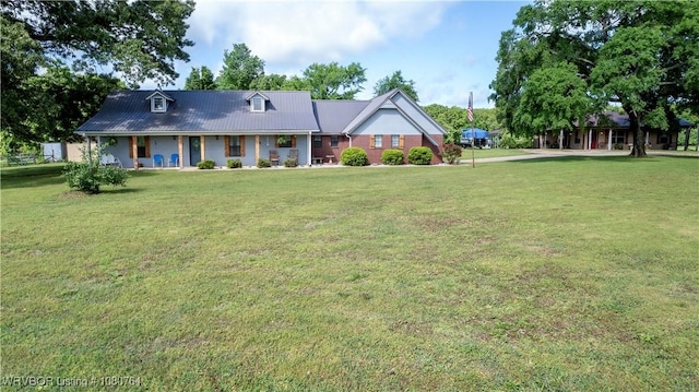 view of front of home with a porch, metal roof, and a front lawn