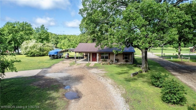 ranch-style home with driveway, metal roof, a front yard, a porch, and a carport