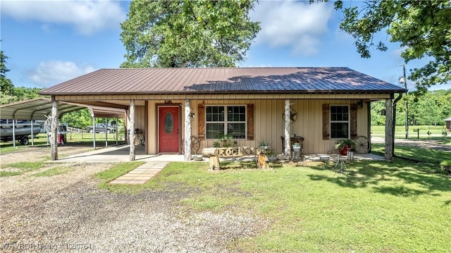 ranch-style house with a porch, driveway, a front yard, metal roof, and a carport