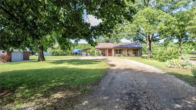 ranch-style home featuring gravel driveway, a front lawn, and a carport