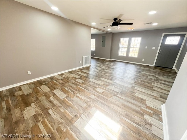 unfurnished living room with baseboards, a ceiling fan, visible vents, and light wood-style floors