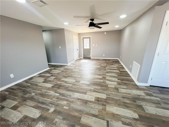 unfurnished room with dark wood finished floors, visible vents, and baseboards