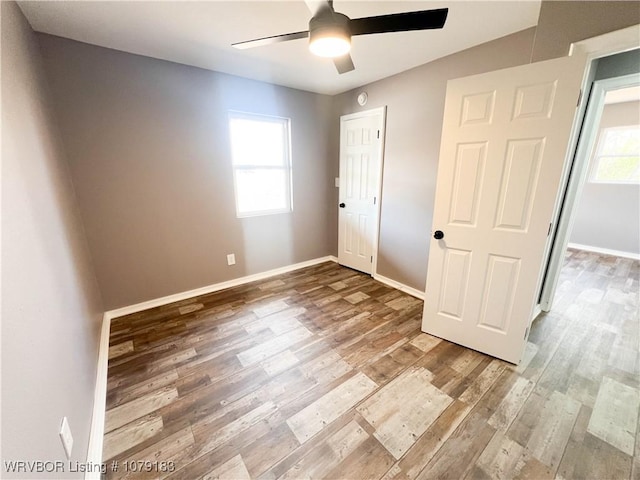 unfurnished bedroom featuring a ceiling fan, baseboards, and wood finished floors