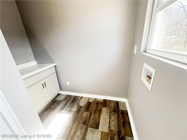 clothes washing area with hookup for a washing machine, dark wood-style flooring, cabinet space, and baseboards