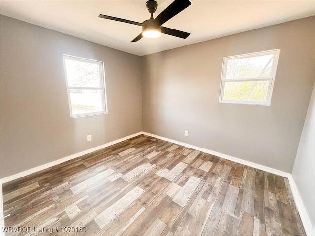 empty room featuring ceiling fan, baseboards, and wood finished floors