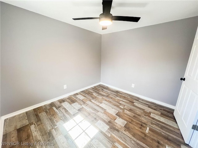 empty room with a ceiling fan, baseboards, and wood finished floors