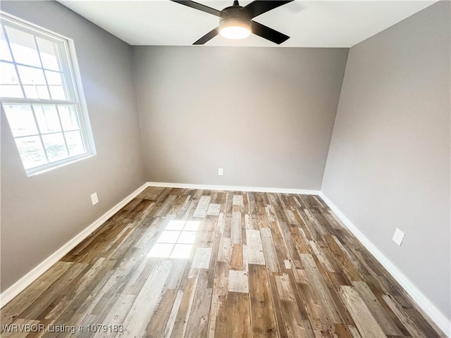 unfurnished room featuring a ceiling fan, baseboards, and wood finished floors