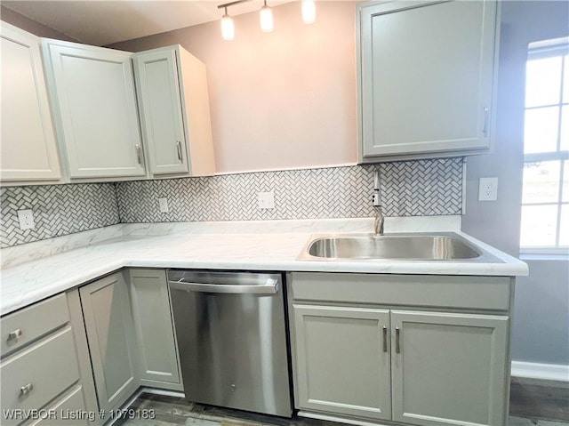 kitchen with a sink, gray cabinets, decorative backsplash, and dishwasher