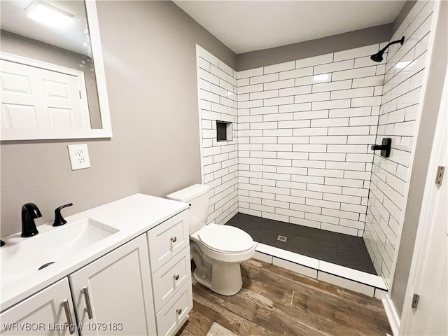 full bathroom featuring toilet, wood finished floors, vanity, and a shower stall