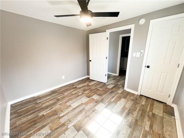 unfurnished bedroom featuring a ceiling fan, baseboards, and wood finished floors