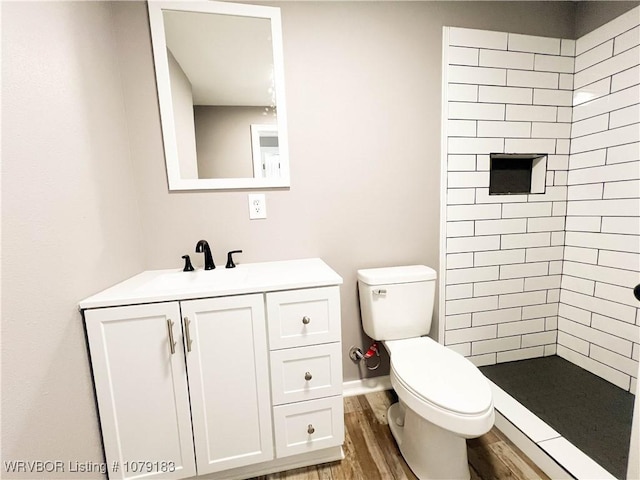 full bathroom featuring toilet, a shower stall, wood finished floors, and vanity