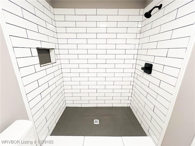 bathroom with tiled shower and toilet